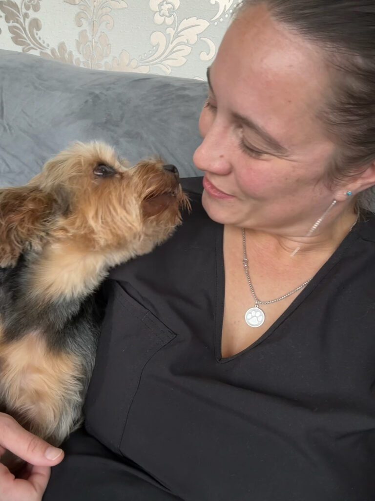 groomer holding a small dog