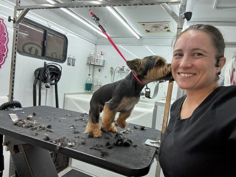 groomer taking a selfie with a dog