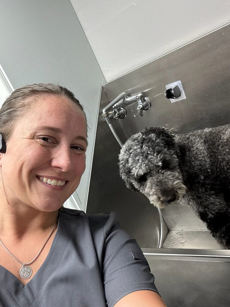 groomer taking a selfie with a dog