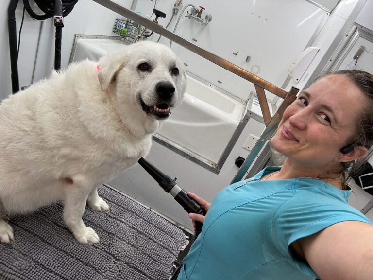 groomer taking a selfie with a dog