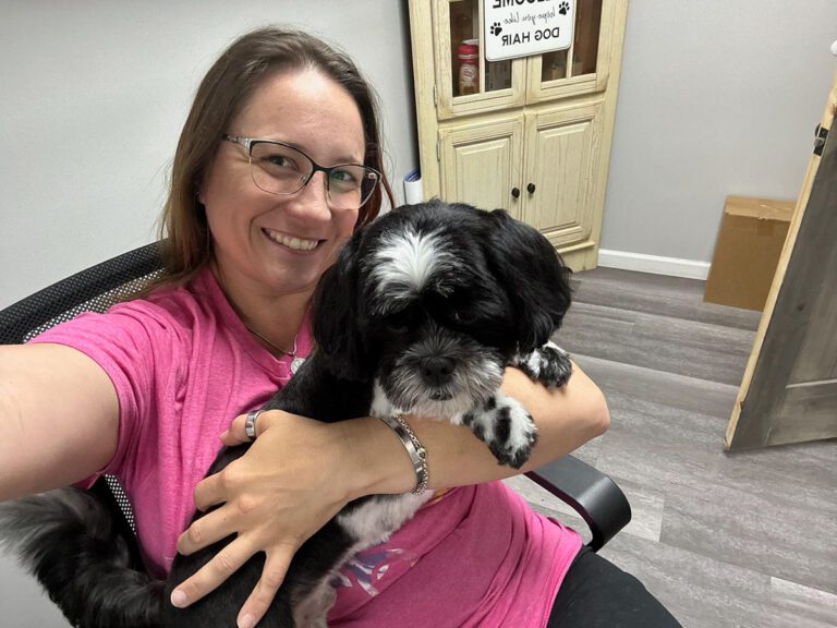 groomer taking a selfie with a dog