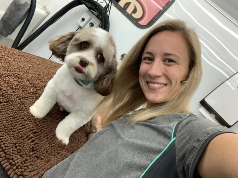 groomer taking a selfie with a dog
