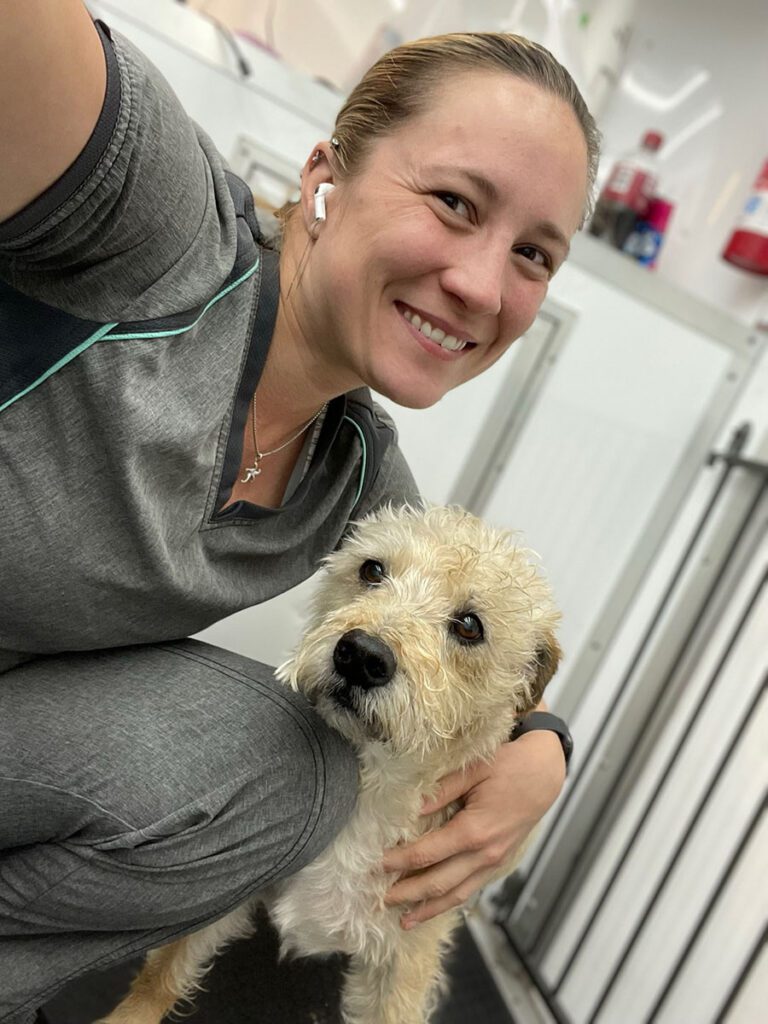 groomer taking a selfie with a dog