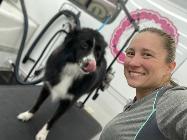 groomer taking a selfie with a dog